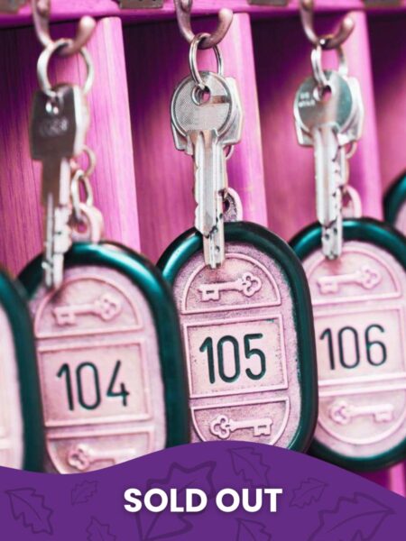 Pink-tinted image of hotel room keys hanging on hooks