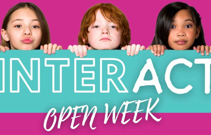 Image of three children peeking over a banner displaying the words interact open week