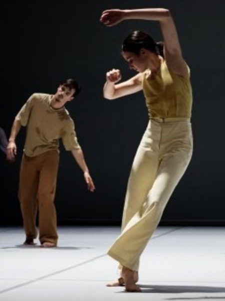 Orla McCarthy performing a dance onstage with a male dancer in the background