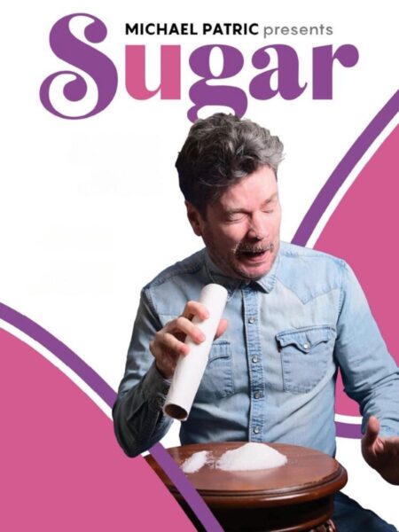 A wincing man pretends to snort sugar off a table through a tube of kitchen towel as if it were cocaine. The words "Michael Patric presents Sugar" are above his head.