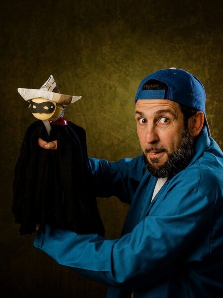 Miquel Barceló dressed in a blue boiler suit holding a pirate puppet in Ballad of a Bandit.