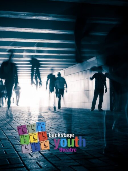 A group of people in silhouette in a darkened tunnel with a bright white light behind them. All Things.