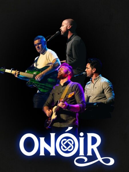 The members of Onóir in performance on a darkened stage. The name of the group appears on the bottom centre of the image.