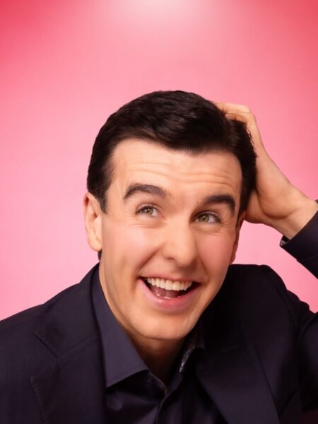 A close-up of a laughing Al Porter laughing and glancing upward while running his left hand through his hair. A promo shot for his show "Algorithm."