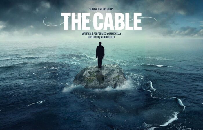 Silhouette of a man standing on a rock amid turbulent ocean waves. Text reads "The Cable," conveying a sense of isolation and introspection.